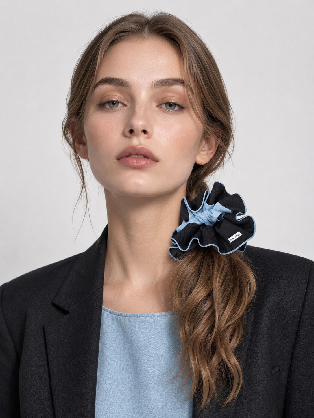 Model wearing a black and blue BetterHalo scrunchie